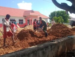 Babinsa Bersama Warga Gotong Royong Meratakan Tanah Timbunan Di Halaman Kantor Camat